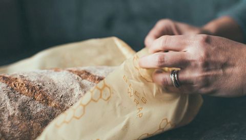 Un beeswrap est utilisé pour couvrir un pain à la place d'un fillm plastique étirable